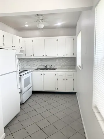a kitchen with white cabinets and white appliances