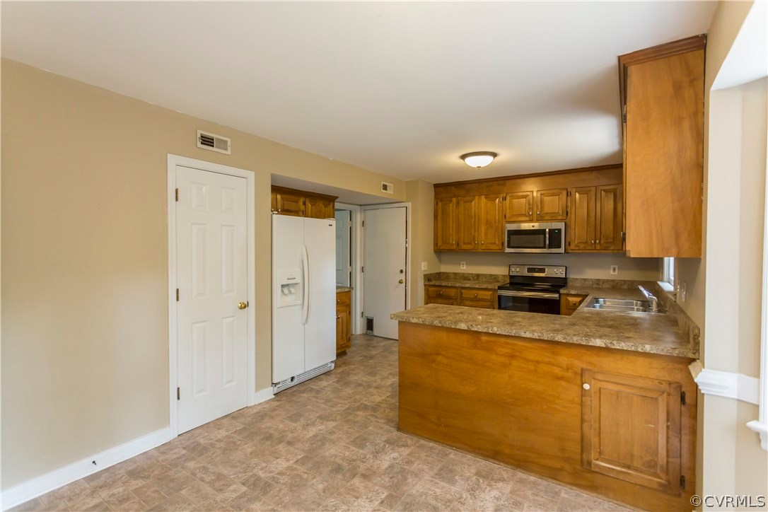 5111 Rock Harbour Road Midlothian, VA 23112 - Photo 18 of 50 a kitchen with a refrigerator a stove top oven and a sink