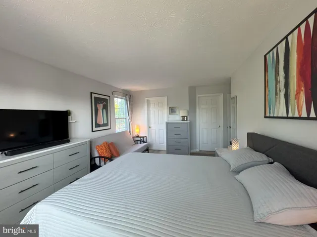 a bedroom with a bed and a flat screen tv