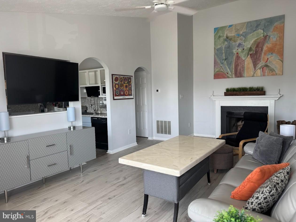 1601 Berry Rose Court, Unit 4 3J Frederick, MD 21701 - Photo 3 of 17 a living room with furniture a flat screen tv and a fireplace