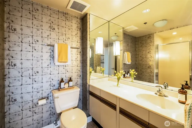 a bathroom with a sink mirror vanity and toilet