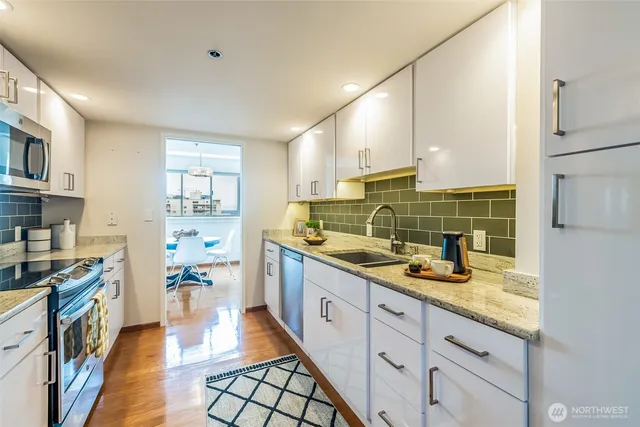 a kitchen with sink refrigerator and cabinets