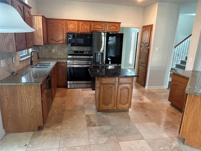 a kitchen with stainless steel appliances a stove a sink and a refrigerator