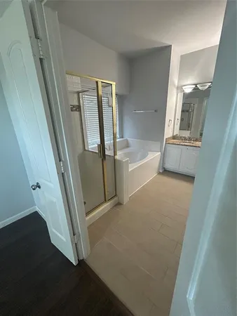 a bathroom with a tub sink and mirror