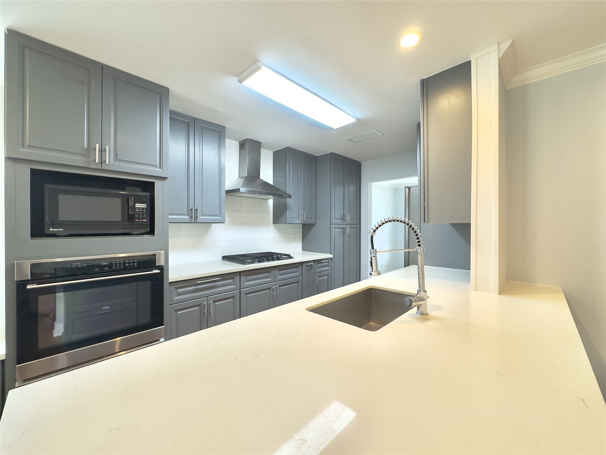 1415 Mapleton Drive Houston, TX 77043 - Photo 13 of 45 a kitchen with stainless steel appliances granite countertop a sink a stove top oven and refrigerator