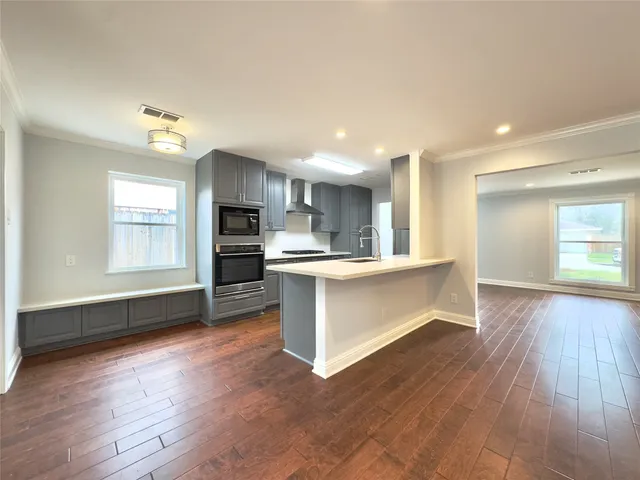 a kitchen with stainless steel appliances kitchen island granite countertop a refrigerator stove and sink