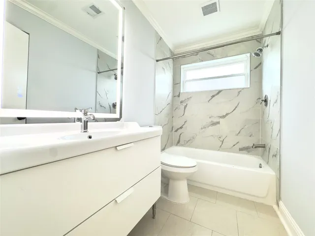 an empty room with wooden floor cabinet and windows