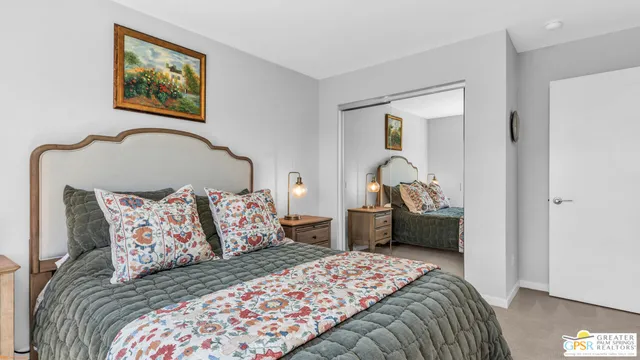 a bedroom with a bed and a painting on the wall