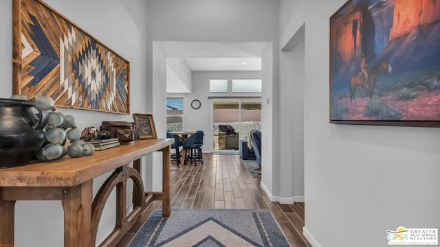 a view of a hallway with wooden floor and furniture