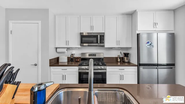 a kitchen with appliances a sink and cabinets