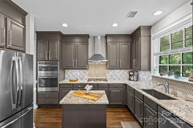 a kitchen with stainless steel appliances granite countertop a refrigerator stove and sink
