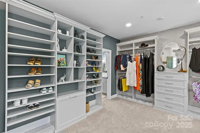 a view of walk in closet with clothes and shoes