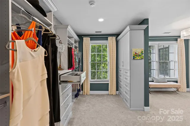 a view of walk in closet with clothes and shoes
