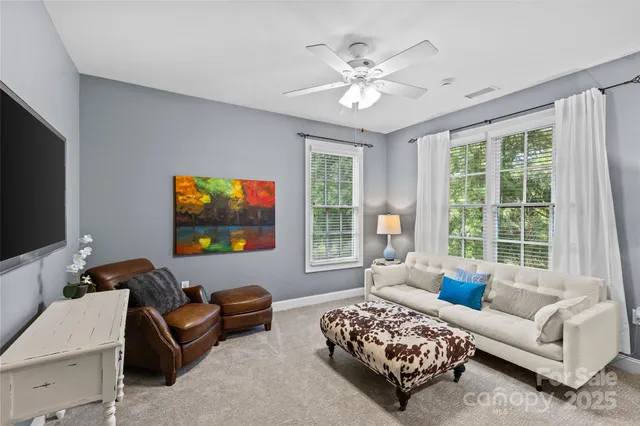 a living room with furniture a large window and a flat screen tv