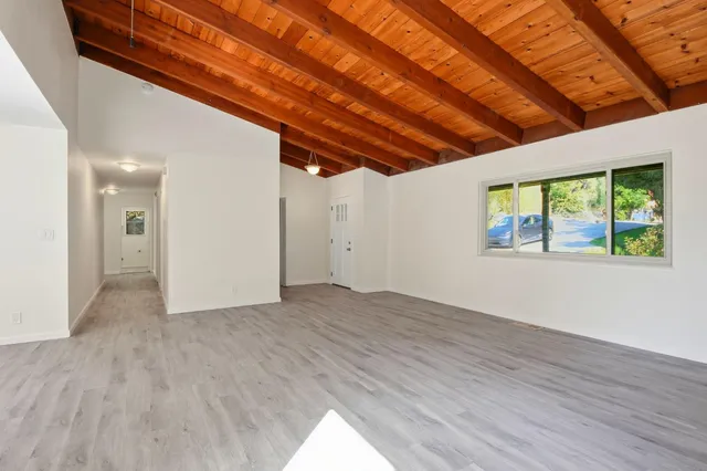 en empty room with wooden floor and windows