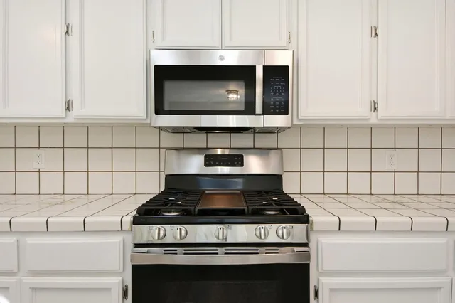 a stove top oven sitting inside of a kitchen