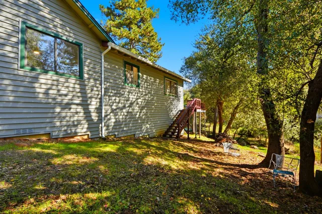 a view of a house with a big yard and large trees