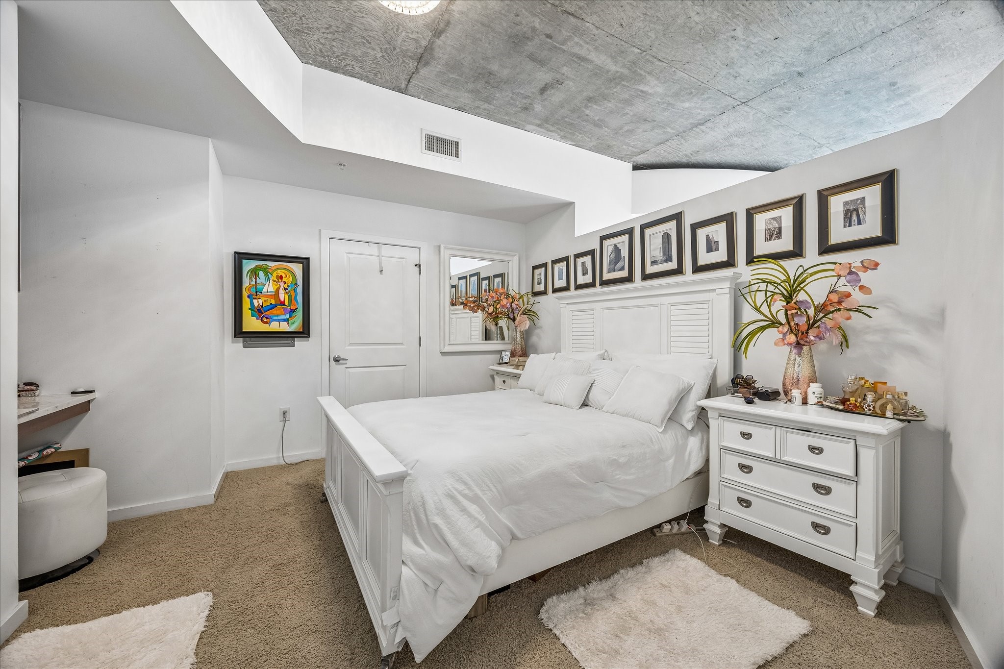 5925 Almeda Road, Unit 11907 Houston, TX 77004 - Photo 2 of 35 Spacious bedroom retreat featuring soft natural light and plush carpeting for comfort, creating a relaxing space leading to the rare walk-in closet.