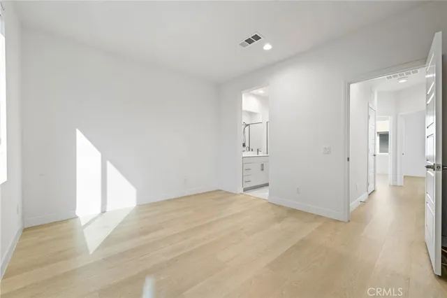 a view of a livingroom with wooden floor and a bathroom