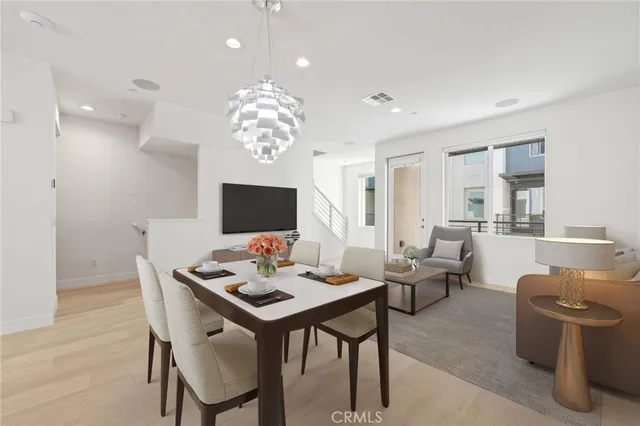 a view of a dining room with furniture a chandelier and wooden floor