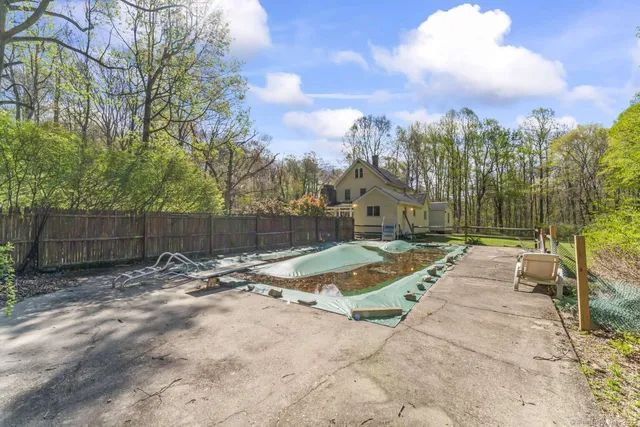 a view of a big house with a big yard and large trees
