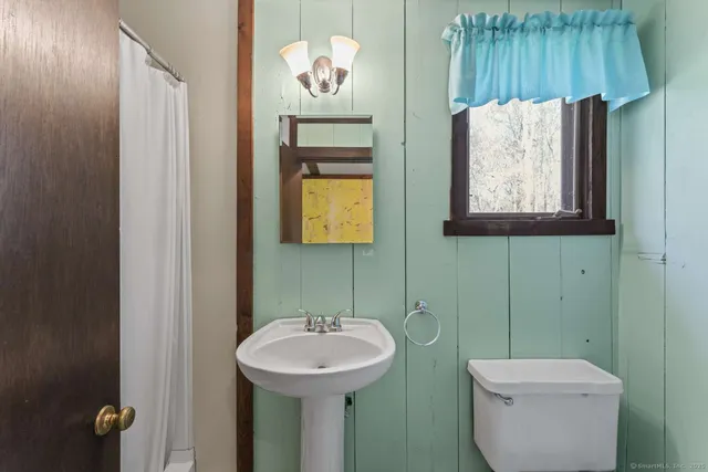 a bathroom with a toilet sink and mirror