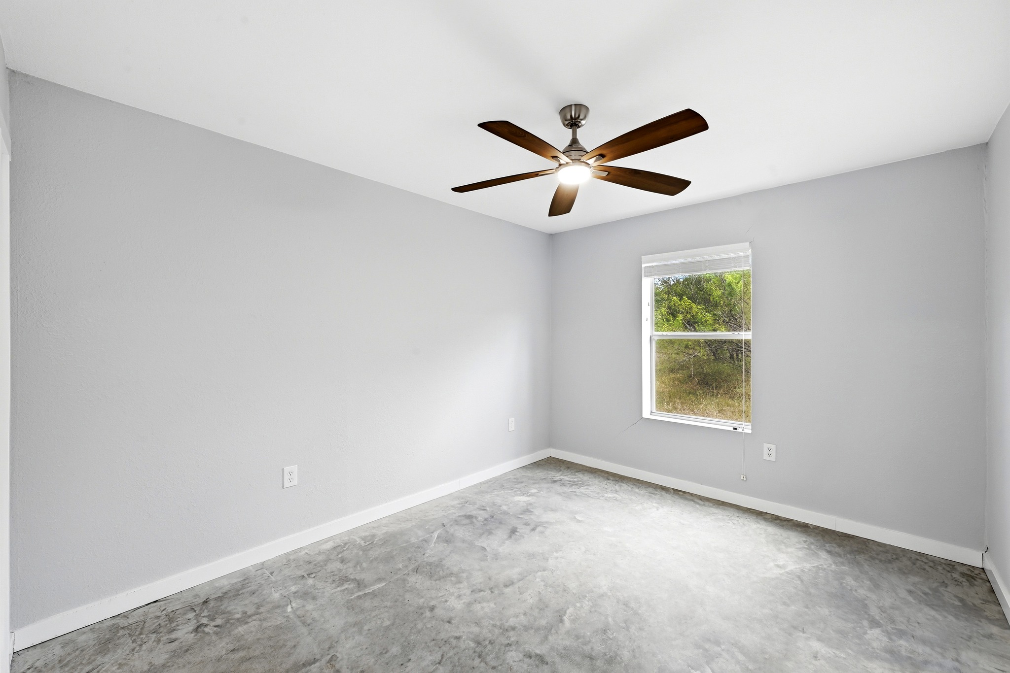 4001 Barth Road Lockhart, TX 78644 - Photo 22 of 38 Polished concrete floors and a large window frame peaceful views of the surrounding greenery.