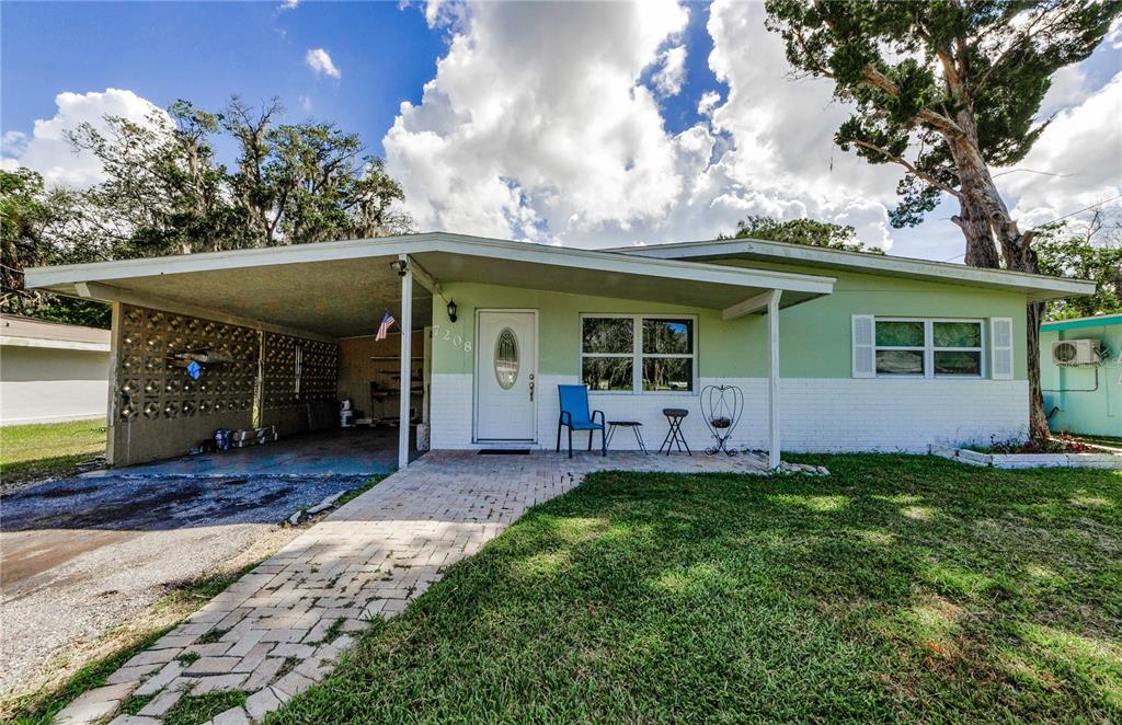a front view of a house with a big yard and a large tree