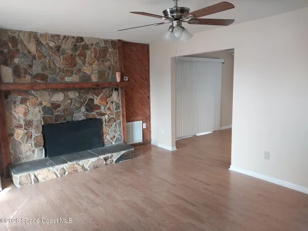 a view of a livingroom with a fireplace and a ceiling fan
