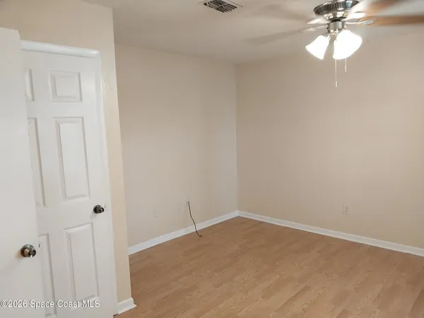 a view of a room with wooden floor and fan