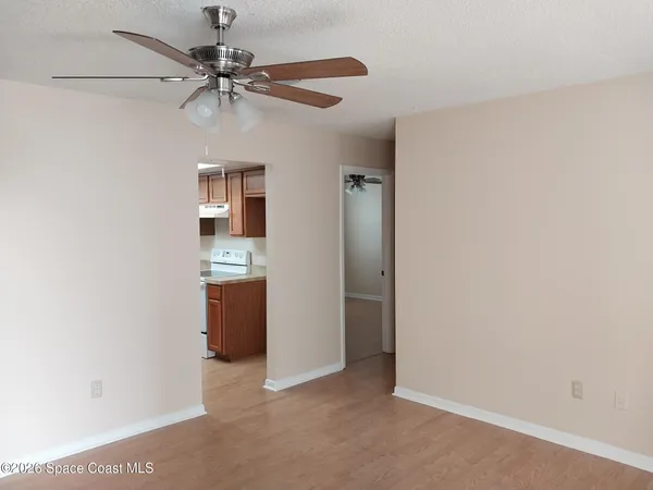 an empty room with a ceiling fan and a window