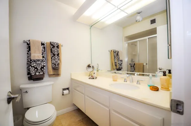 a bathroom with a sink vanity mirror and toilet