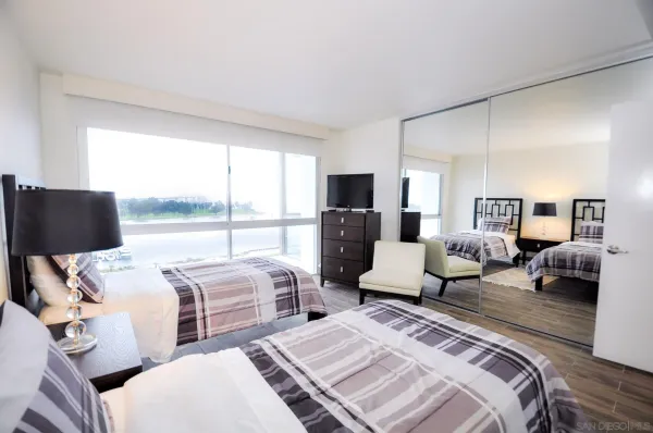 a bedroom with two beds and large window