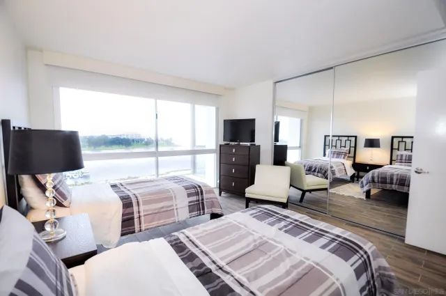 a bedroom with two beds and large window