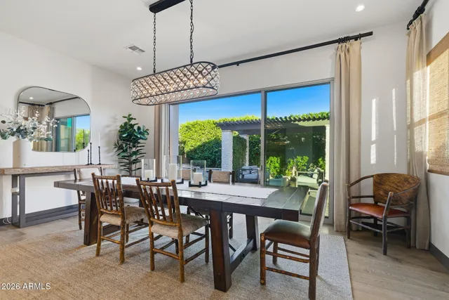 a dining room with furniture a chandelier and wooden floor