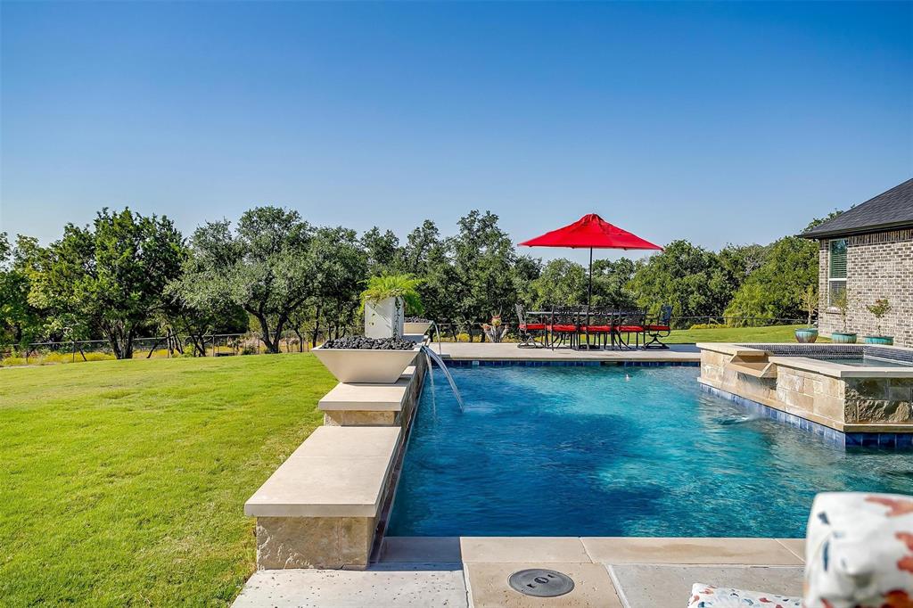 2161 Eagles Rdg Drive Weatherford, TX 76087 - Photo 36 of 40 a view of a swimming pool with lawn chairs under an umbrella