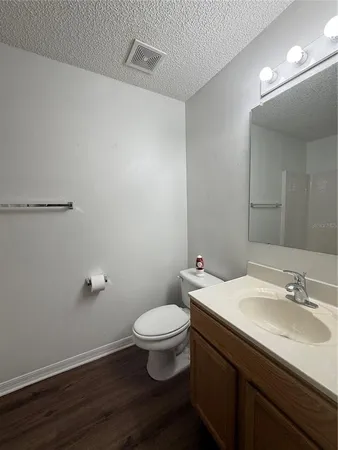 a bathroom with a granite countertop sink toilet and a mirror