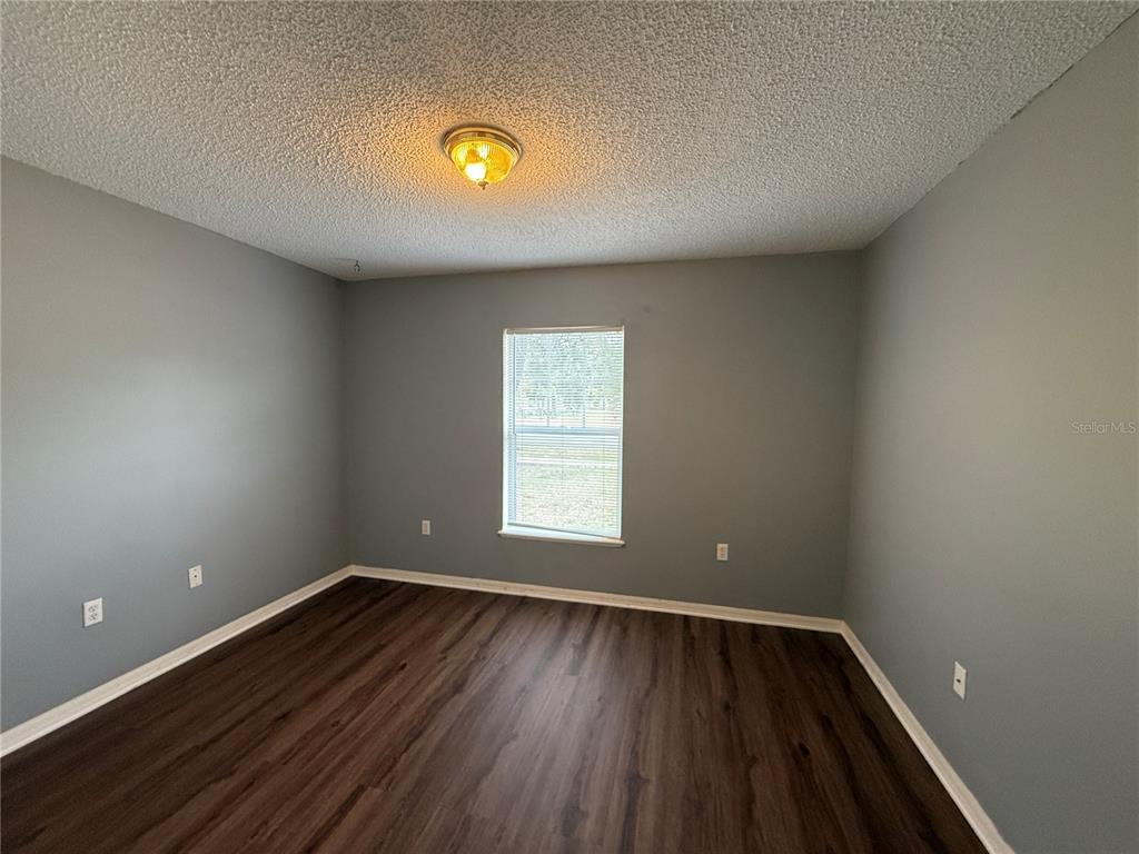 2156 Deltona Boulevard Spring Hill, FL 34606 - Photo 18 of 21 a view of an empty room with wooden floor and window