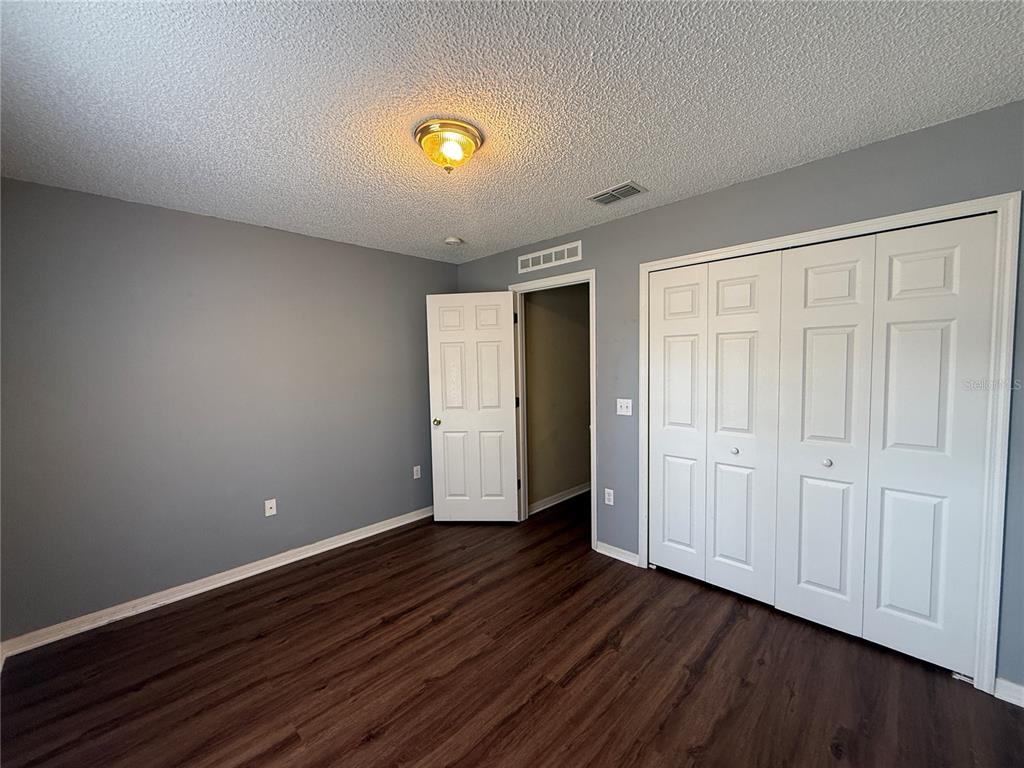 2156 Deltona Boulevard Spring Hill, FL 34606 - Photo 19 of 21 a view of an empty room with wooden floor and closet