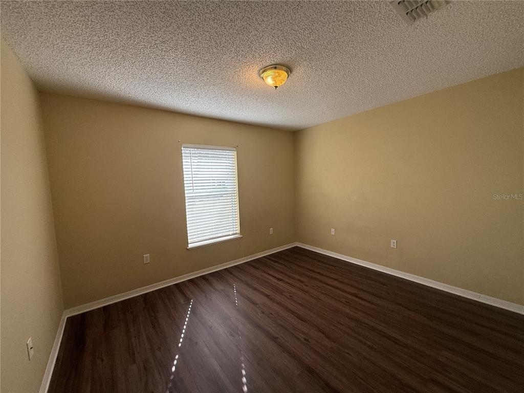 2156 Deltona Boulevard Spring Hill, FL 34606 - Photo 20 of 21 a view of an empty room with wooden floor and a window