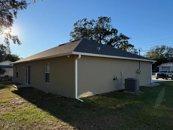 a backyard of a house with wooden fence and a tree