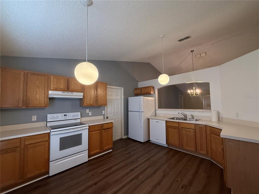 2156 Deltona Boulevard Spring Hill, FL 34606 - Photo 6 of 21 a kitchen with cabinets wooden floor and stainless steel appliances