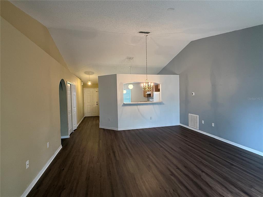 2156 Deltona Boulevard Spring Hill, FL 34606 - Photo 8 of 21 an empty room with wooden floor a ceiling fan and windows