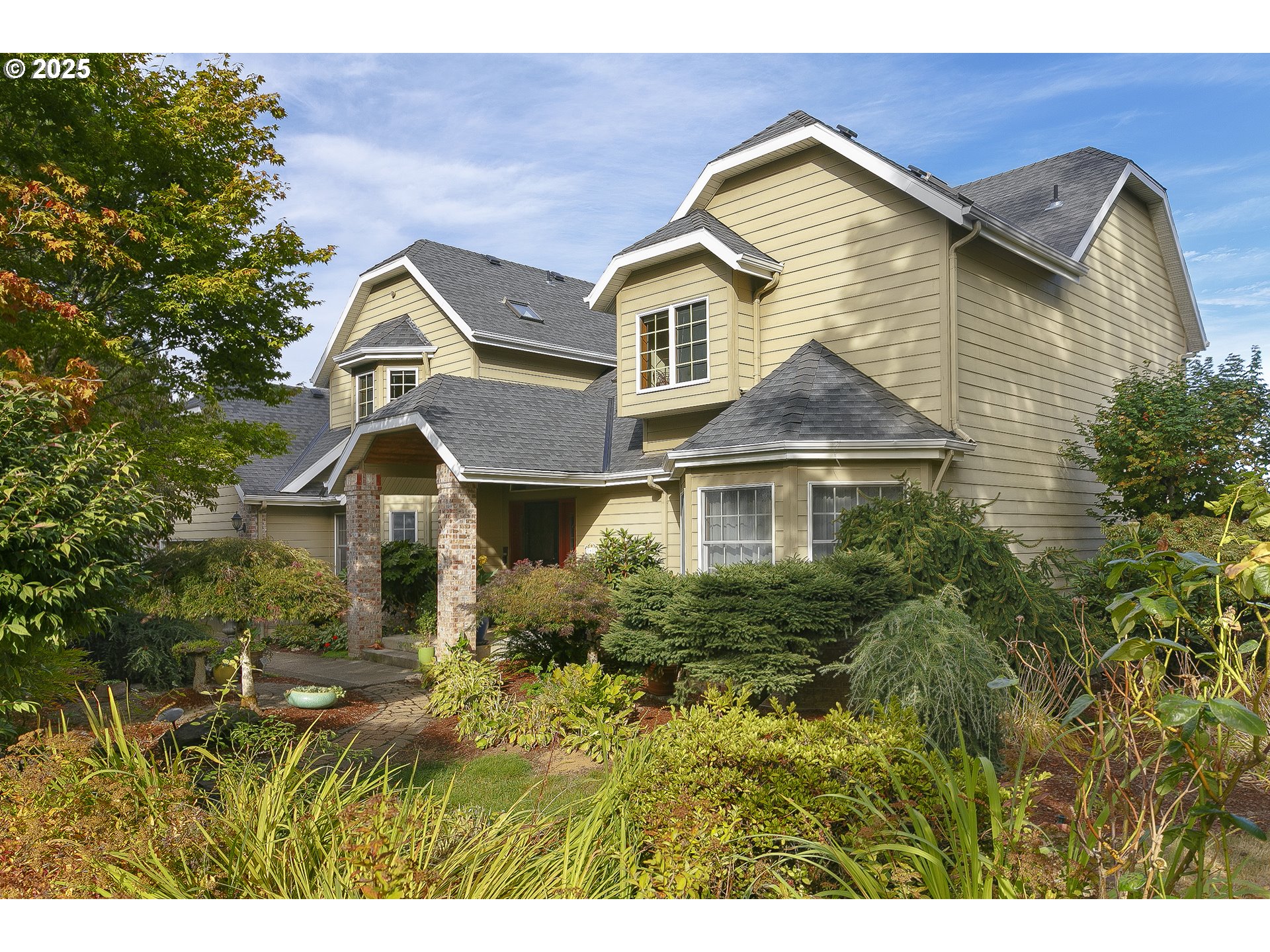 a front view of a house with a yard and trees