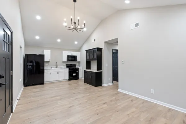 a large kitchen with stainless steel appliances kitchen island granite countertop a refrigerator and a stove top oven