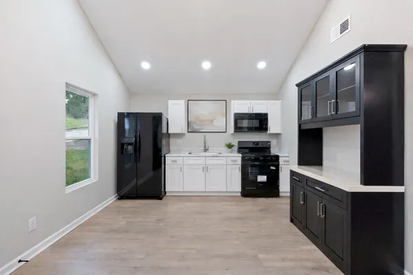 a kitchen with stainless steel appliances granite countertop a refrigerator and a stove top oven