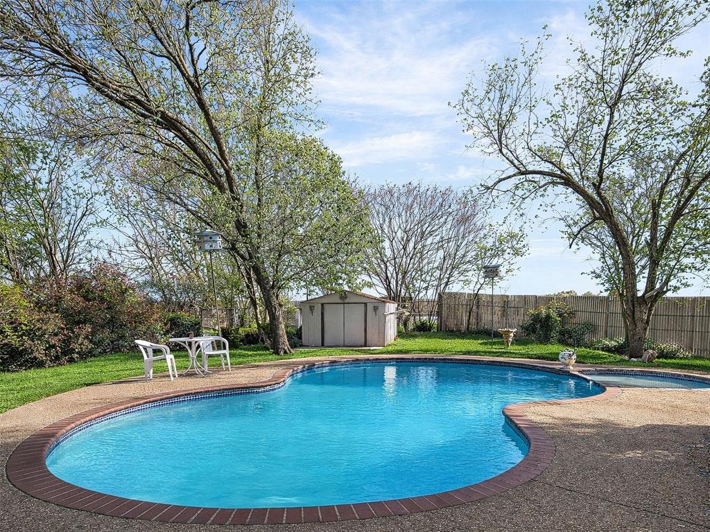 1006 Oakchase Court Azle, TX 76020 - Photo 15 of 19 a view of a swimming pool with trees in the background