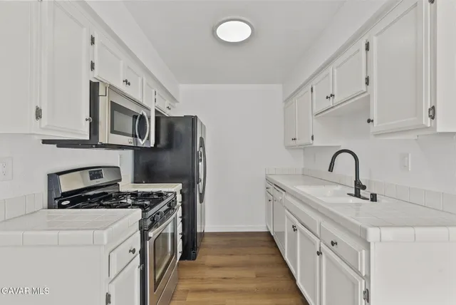 a kitchen with stainless steel appliances a sink stove and cabinets