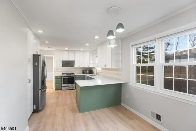 a kitchen with stainless steel appliances kitchen island wooden cabinets and refrigerator
