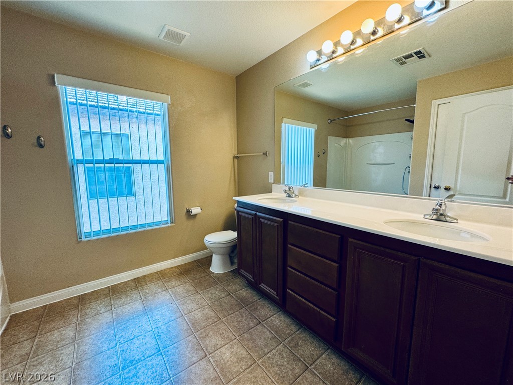 8617 Palomino Ranch Street Las Vegas, NV 89131 - Photo 24 of 27 Double vanity with ample counter space and a large mirror defines this bright bathroom.